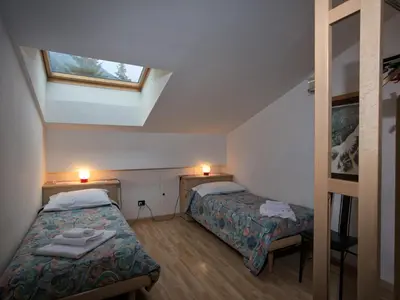 two beds in a small room with a skylight at Apartment in Predazzo near Dolomiti Superski in Predazzo