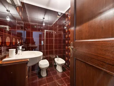 a bathroom with a toilet and a sink and a door at Apartment in Predazzo near Dolomites Trails in Predazzo