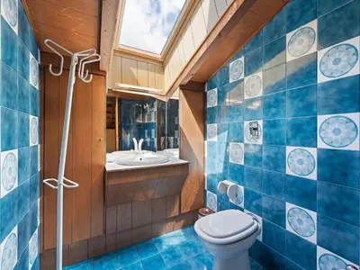 a bathroom with a toilet and a sink and a window at Apartment in Predazzo near Dolomites Trails in Predazzo