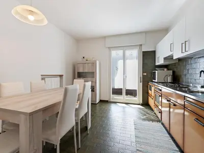 a kitchen with a wooden table and white chairs at Apartment in Predazzo near Dolomites Trails in Predazzo