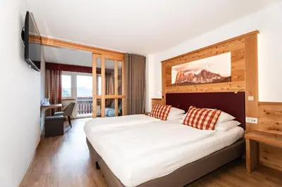a bedroom with a large bed in a room at Astor Suites B&B in Selva di Val Gardena