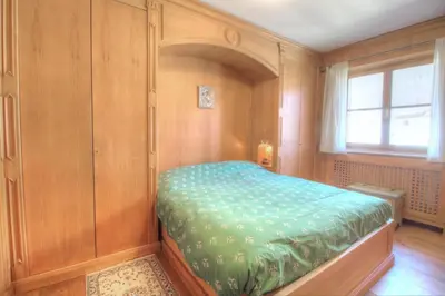 a bedroom with a bed in a room with a window at Botton d'oro in Borca di Cadore