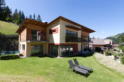 a house on a hill with a bench in the yard at Antorè in Badia