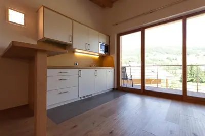 a kitchen with white cabinets and a large window at Antorè in Badia