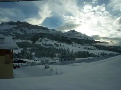 a view of a snow covered mountain with trees and a building at Antorè in Badia
