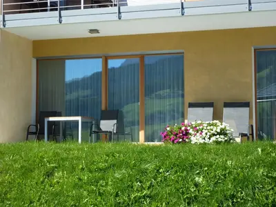 a building with a flower pot in the grass at Antorè in Badia