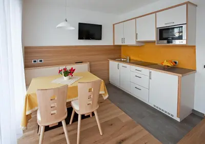 a kitchen with a table and chairs in a kitchen at Antorè in Badia
