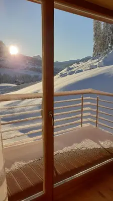 a sliding glass door with a view of the snow at Antorè in Badia