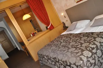 a hotel room with a bed and a window at Residence Anda in Pozza di Fassa