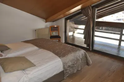 a bedroom with a bed and a large window at Residence Anda in Pozza di Fassa