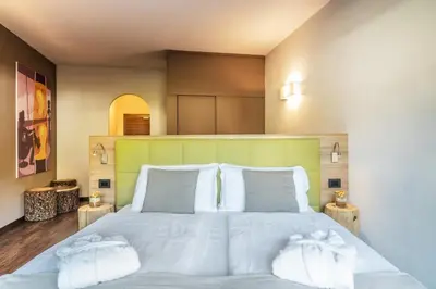 a bedroom with a large white bed with two pillows at Residence Anda in Pozza di Fassa