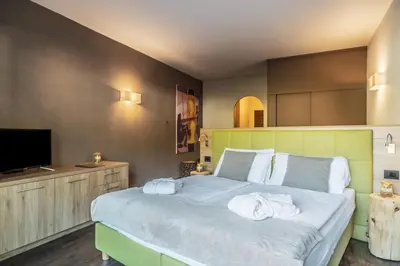 a bedroom with a large bed with towels on it at Residence Anda in Pozza di Fassa