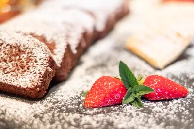 a couple of strawberries on a table with brownies at Garni Volgger in Brunico