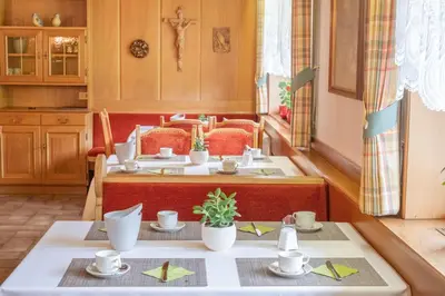 a dining room with two tables with cups and saucers at Garni Volgger in Brunico