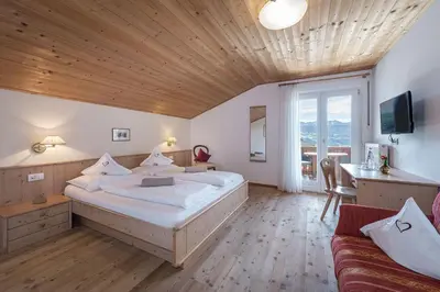 a bedroom with a large bed and a couch at Tirolerhof guesthouse in Naz-Sciaves