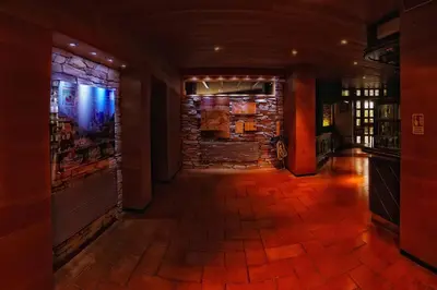 a hallway of a bar with a brick wall at Hotel Paladin in San Martino di Castrozza