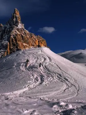 a snow covered hill with a mountain in the background at Hotel Paladin in San Martino di Castrozza