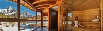 a room with a view of the mountains through a window at Hotel Paladin in San Martino di Castrozza