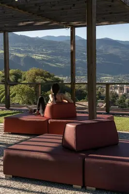 a bedroom with a bed and a chair and a desk at Haller Suites & Restaurant in Bressanone