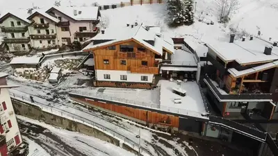 a wooden house with snow on the roof at Cesa Prinoth in Campitello di Fassa