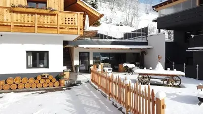 a house with a fence and a horse drawn carriage at Cesa Prinoth in Campitello di Fassa