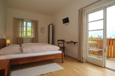 a bedroom with a bed and a sliding glass door at Schiessstandhof in Montagna