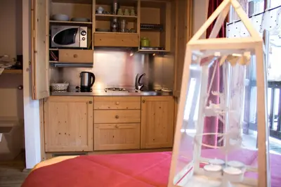 a kitchen with wooden cabinets and a counter top at Residence Valpiccola in Val di Zoldo