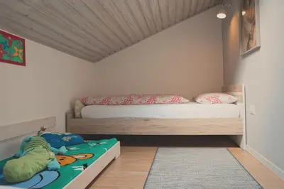 a childs bedroom with a bed and a rug at Niederhof life in Lana