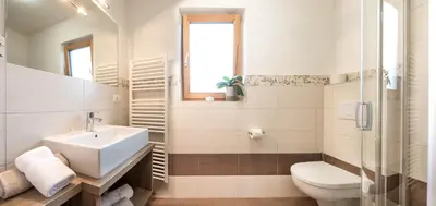 a white bathroom with a sink and a toilet at Niederhof life in Lana