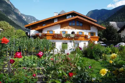a house with a flower garden in front of it at Zur Brücke apartments and rooms - Your home in heart of South Tyrol, with Brixencard in Fortezza