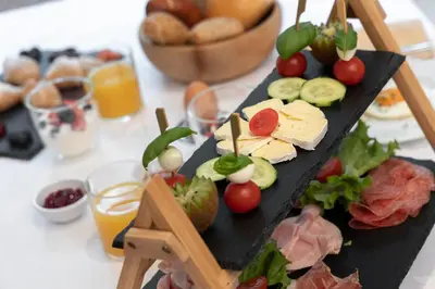 a plate of food with cheese and vegetables on a table at Zur Brücke apartments and rooms - Your home in heart of South Tyrol, with Brixencard in Fortezza