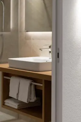 a bathroom with a white sink and a mirror at Zur Brücke apartments and rooms - Your home in heart of South Tyrol, with Brixencard in Fortezza