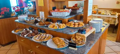 a buffet line with different types of bread and pastries at Hotel Miramonti in Vigo di Fassa