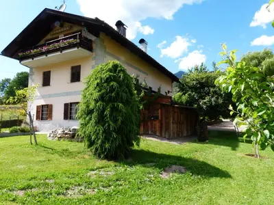 a house with a large bush in front of it at Maso Pinterato in Cavalese