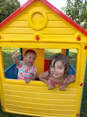 two children playing in a yellow play house at Maso Pinterato in Cavalese
