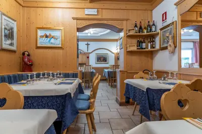 a waiting room with chairs and a table at Hotel Mary in Pozza di Fassa