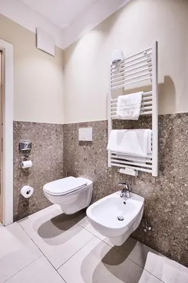 a white bathroom with a toilet and a sink at Hotel Jarolim in Bressanone