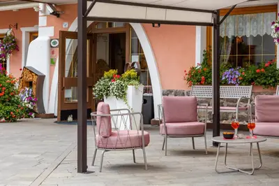 a group of chairs and a table in front of a building at Hotel La Serenella in Moena