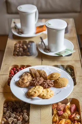 a table topped with plates of food and cups of coffee at Hotel La Serenella in Moena