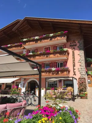 a pink building with flowers in front of it at Hotel La Serenella in Moena