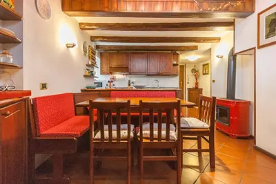 a kitchen with a table and chairs in a kitchen at Casa Silva in Falcade
