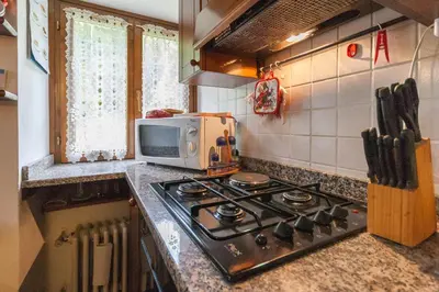 a kitchen with a stove and a microwave at Casa Silva in Falcade