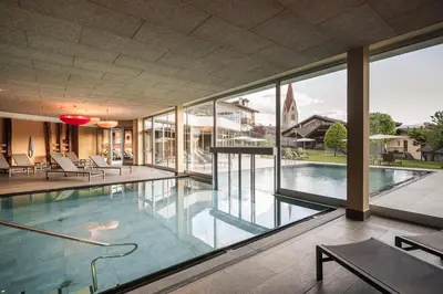 a large swimming pool with a large glass wall at Hotel Gasserhof in Bressanone