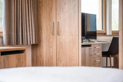 a room with a desk with a television and a bed at Hotel Gasserhof in Bressanone