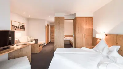 a hotel room with two beds and a television at Hotel Gasserhof in Bressanone