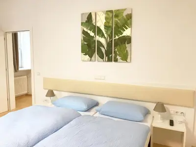 a bedroom with two beds and a painting on the wall at Manzoni Premium in Merano