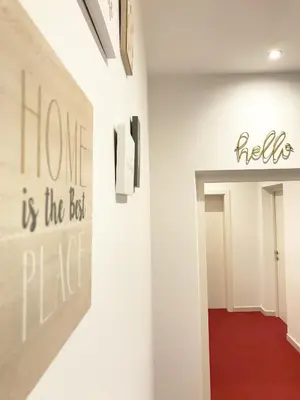 a hallway with a wall with a sign that says home is the best place at Manzoni Premium in Merano