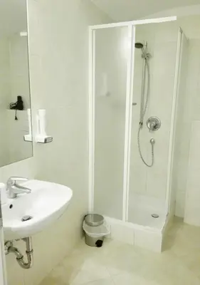 a white bathroom with a shower and a sink at Manzoni Premium in Merano
