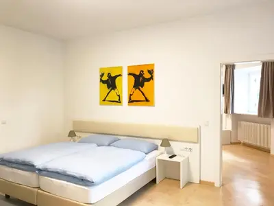 a bedroom with a bed with two paintings on the wall at Manzoni Premium in Merano