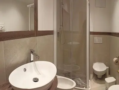 a bathroom with a sink and a shower and a toilet at Post Hotel Moena in Moena